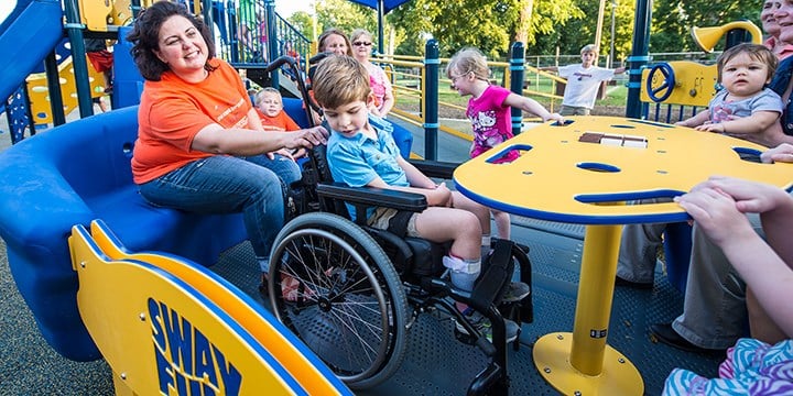 children using inclusive playground equipment
