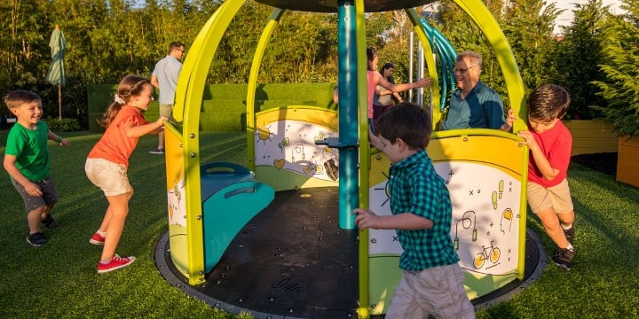 kids using accessible merry-go-round