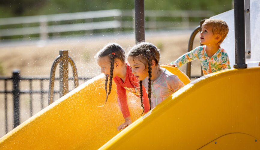 girls going down a slide with water