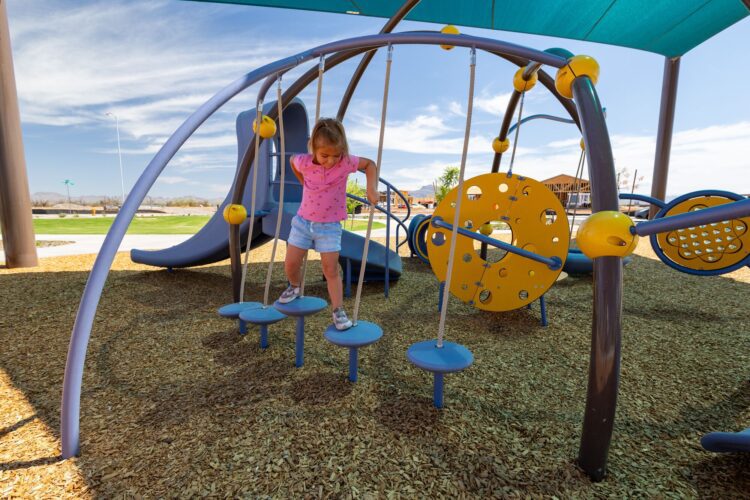 girl climbing across hanging ropes