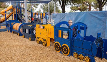 Children play in replica train at playground