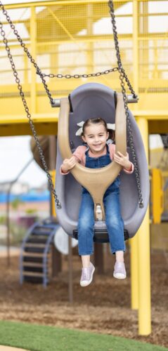 Child rides safety swing at playground in Apache Junction, AZ