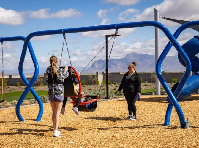 Children and adults play on a two-person swing in Apache Junction, AZ