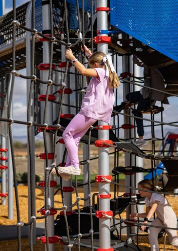 Child climbing on cables at a playground in Apache Junction, AZ