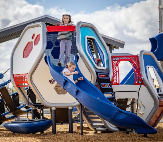 Children play on slide at playground in Apache Junction, AZ