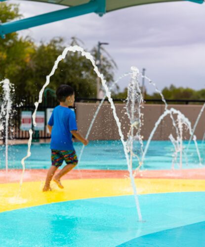 Child playing at outdoor splash pad park