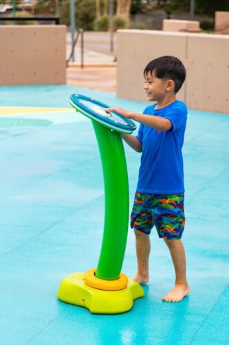 Child playing at outdoor splash pad park