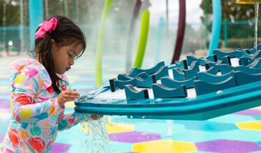Child plays at splash pad, Manzano Mesa Park in Albuquerque, NM