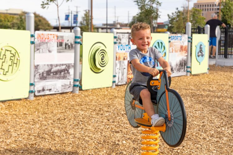 Child rides bouncy rider at Wells Park, Albuquerque, NM