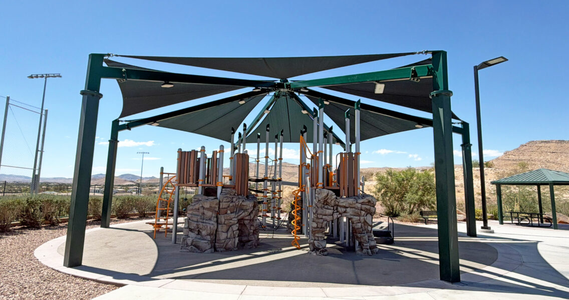 Commercial playground at Olympia Sports Park in Las Vegas, NV with shade, net climbers, slides, and site amenities.