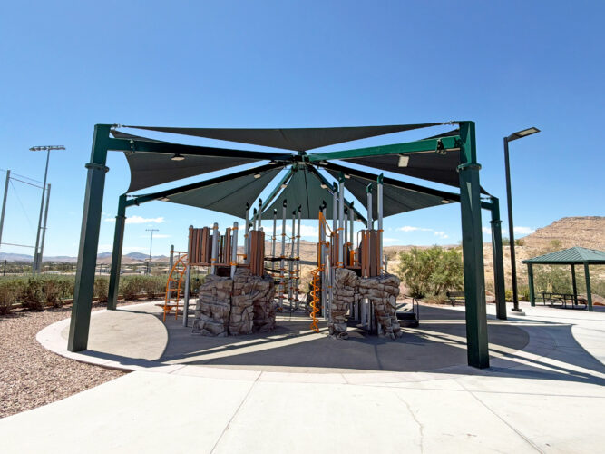 Commercial playground at Olympia Sports Park in Las Vegas, NV with shade, net climbers, slides, and site amenities.