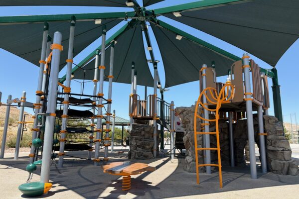 Commercial playground at Olympia Sports Park in Las Vegas, NV with shade, net climbers, slides, and site amenities.