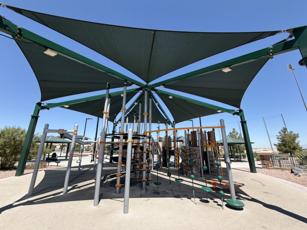 Commercial playground at Olympia Sports Park in Las Vegas, NV with shade, net climbers, slides, and site amenities.