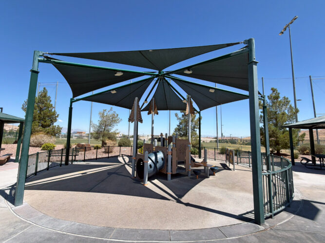 Commercial playground at Olympia Sports Park in Las Vegas, NV with shade, net climbers, slides, and site amenities.
