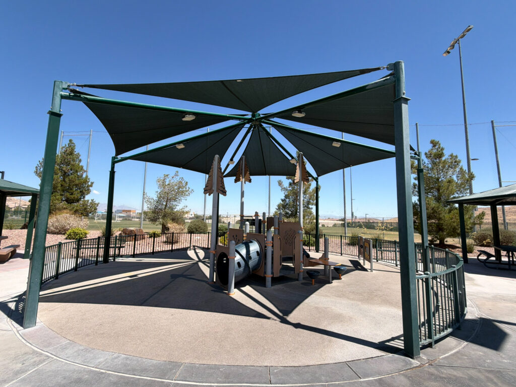 Commercial playground at Olympia Sports Park in Las Vegas, NV with shade, net climbers, slides, and site amenities.