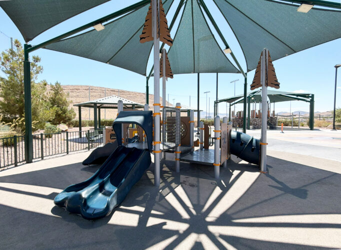 Commercial playground at Olympia Sports Park in Las Vegas, NV with shade, net climbers, slides, and site amenities.