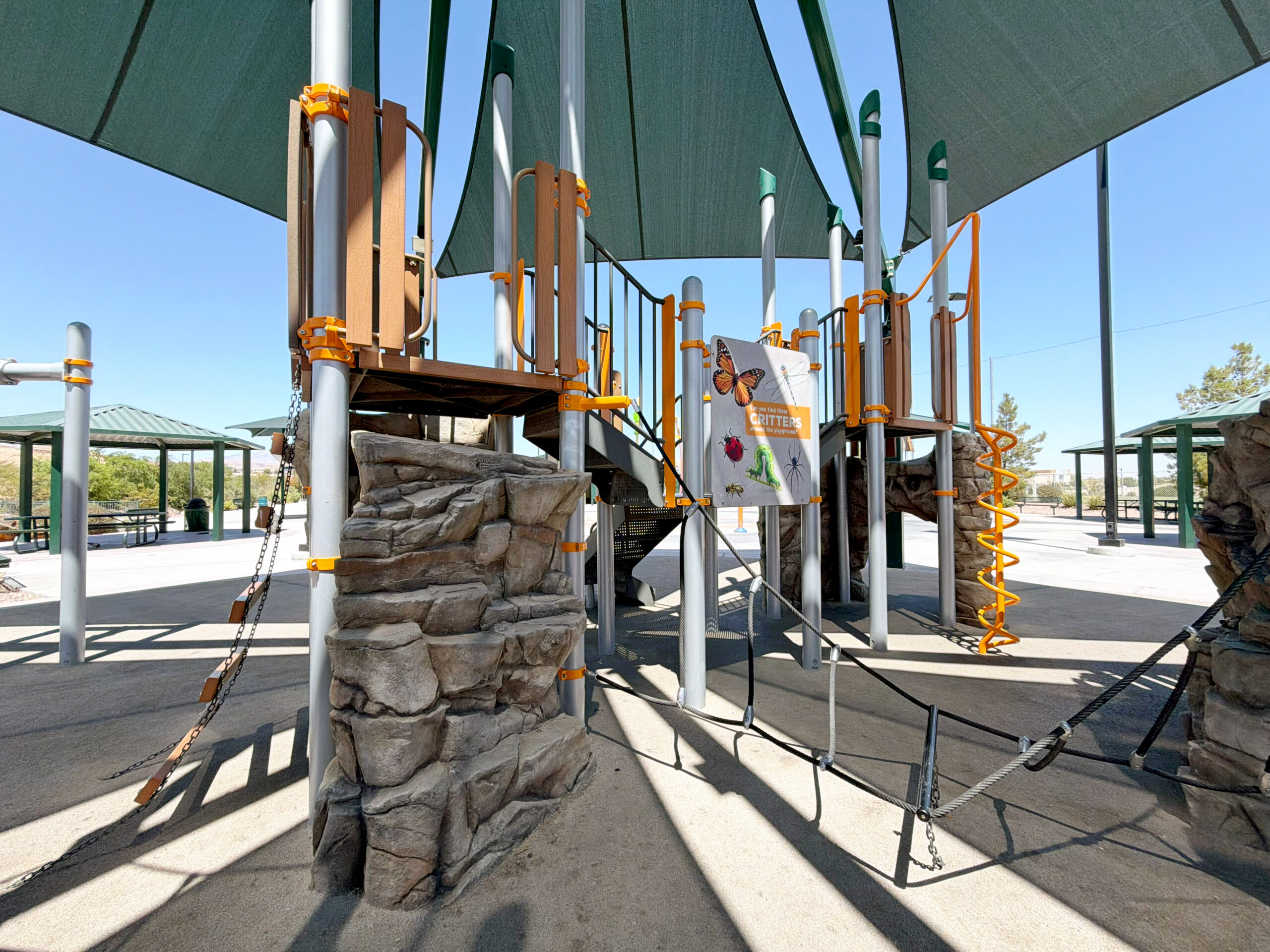 Commercial playground at Olympia Sports Park in Las Vegas, NV with shade, net climbers, slides, and site amenities.