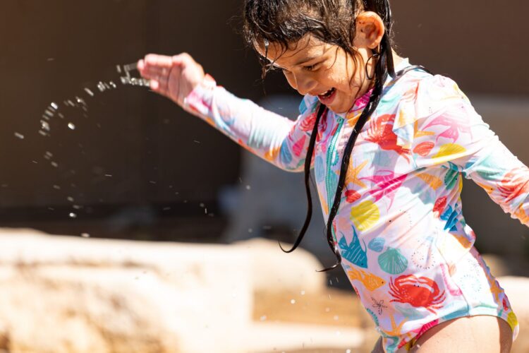 Happy child playing at splash pad at Albuquerque BioPark, in Albuquerque, New Mexico