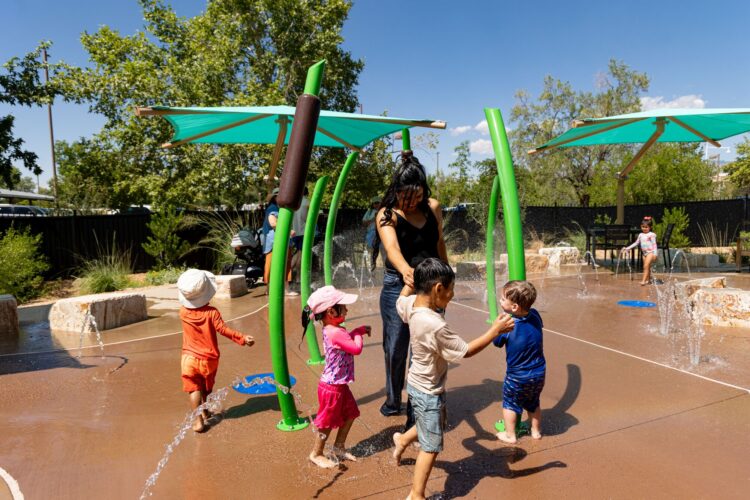 Parents and children play at splash pad at Albuquerque BioPark, in Albuquerque, New Mexico