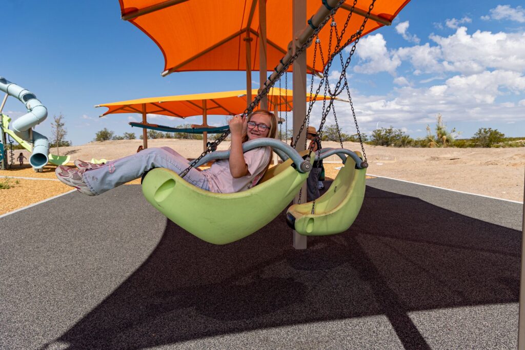 Children swing at East Mesa Public Recreation Complex, in Las Cruces, New Mexico